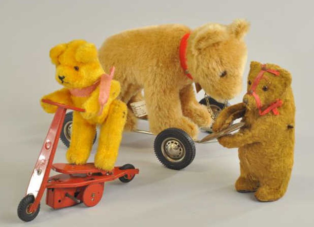 THREE ASSORTED TEDDY BEARS: One clockwork bear holding symbols, one clockwork bear on tin scooter, and bear on wire platform w/rubber tires pull toy, tag marked "GEBR Hermann West Germany." 5" - 6" h.