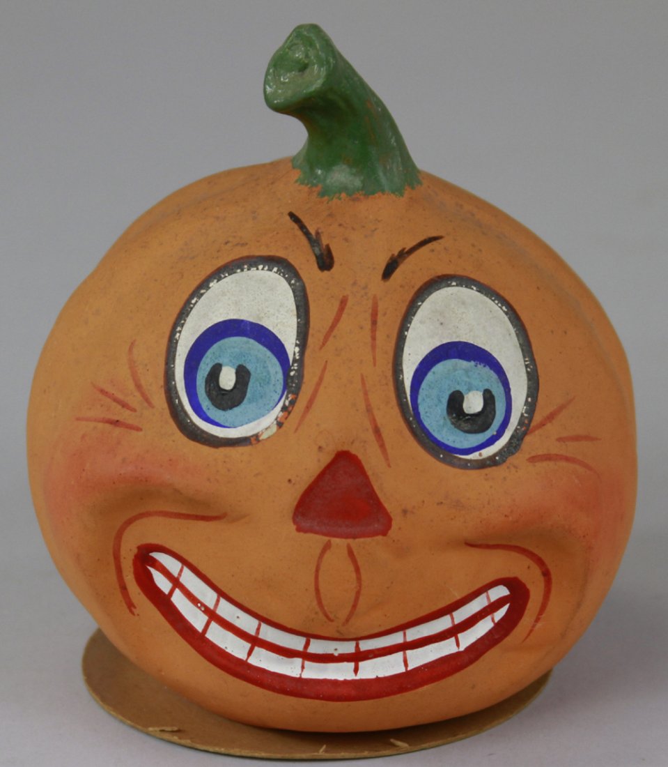 JACK-O-LANTERN CANDY CONTAINER: Germany, composition container done in colorful facial colors, orange overall, green painted stem on head, base removes for candy. 5 1/2" h.