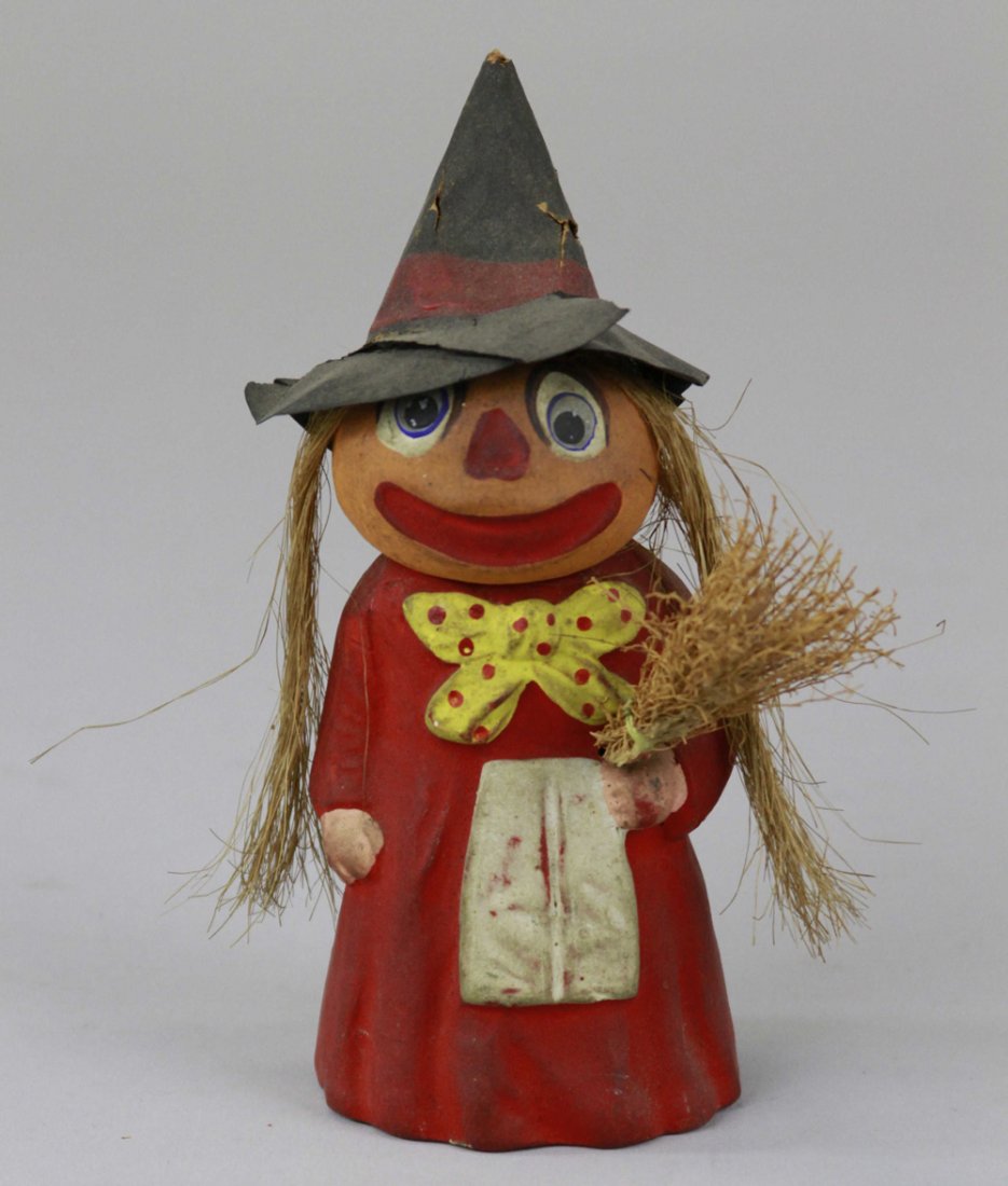 PUMPKIN HEAD WITCH HALLOWEEN FIGURE: Early pumpkin head witch holding broom, stamped Germany, head very colorful and detailed overall, composition papier mâché , scarce example. 6 1/2" h.