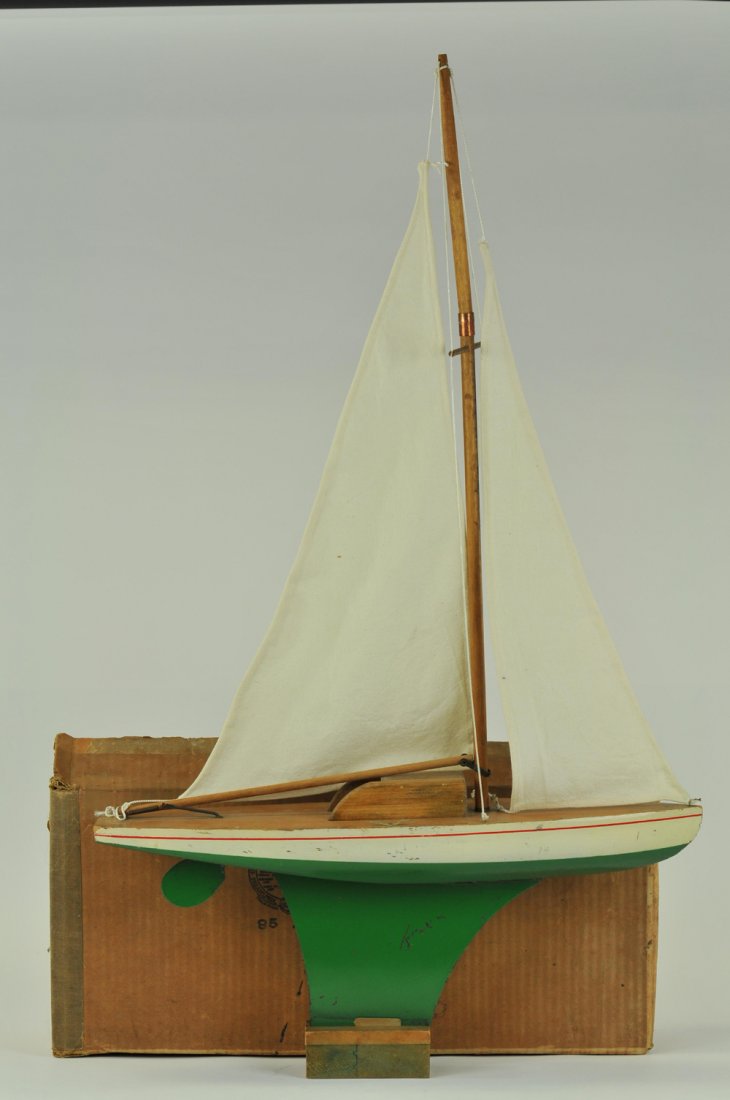 SCHOENHUT WOODEN HULL YACHT WITH BOX: U.S.A., #85/22C, well built model sail boat, painted in green and white hull, features pressed steel keel and wooden mast. 36" h. x 22" w.