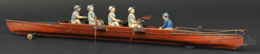 FOUR MAN SCULL WITH COXSWAIN: Gunthermann, Germany, lithographed tin, striped blue uniforms represent collegiate entries, clockwork driven, articulated action, sleek hull design, nice simulated wood grain finish. 22" l.