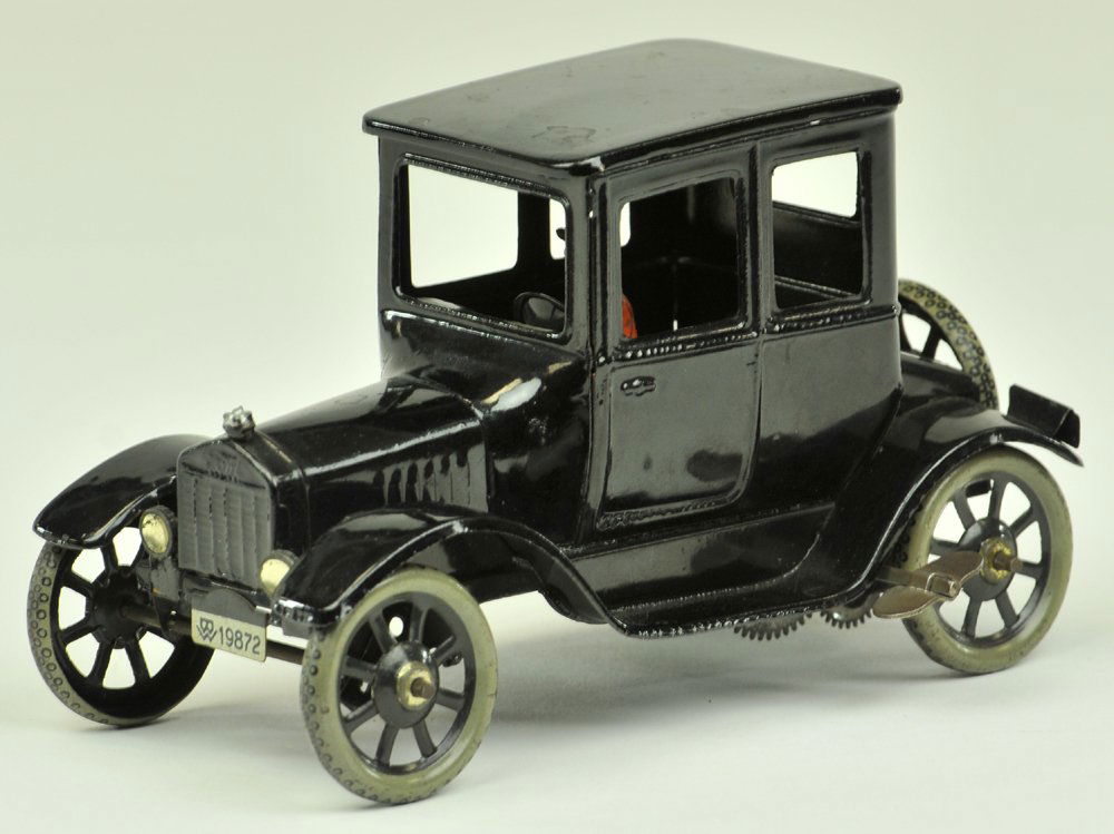 BING MODEL 'T' FORD COUPE: Germany, c. 1920's, painted in black overall, clockwork action, spoke wheels, seated lady driver. 6 1/2" l.