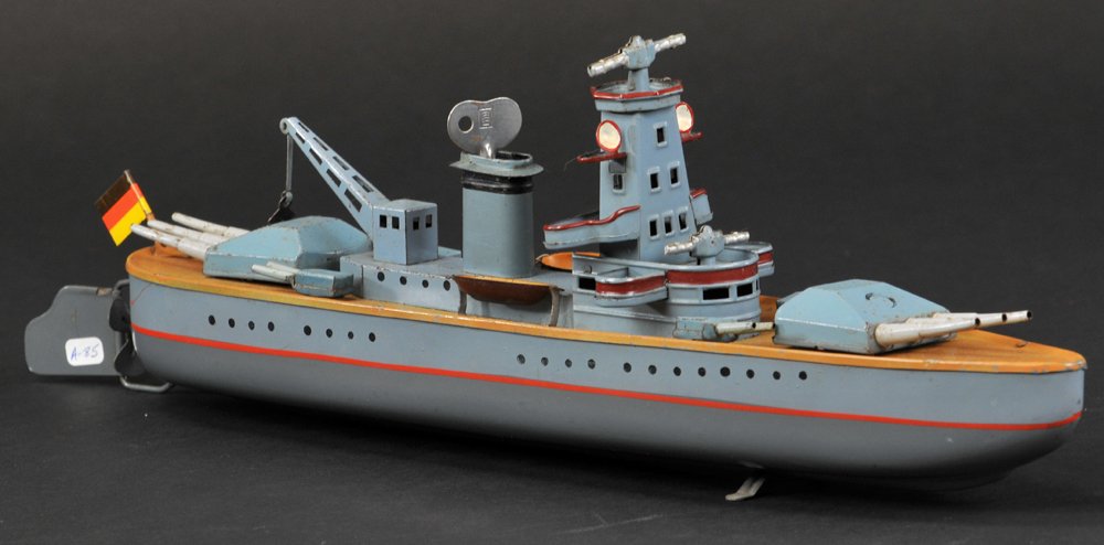 ARNOLD BATTLESHIP: Germany, lithographed tin, very busy deck, features cannons, crane, side guns, multi-tiered observation platforms, key wind driven, done in grey, blue, and mustard deck. 14" l.