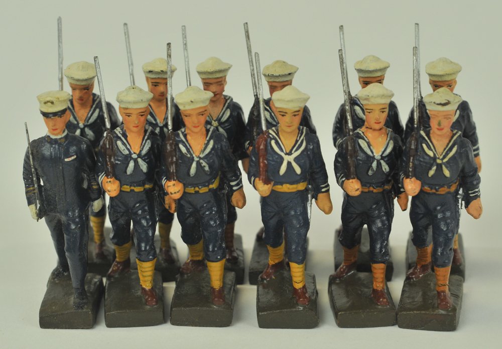 GROUPING OF LINEOL FIGURES: US Blue Jackets, including 11 marching sailors and an officer.