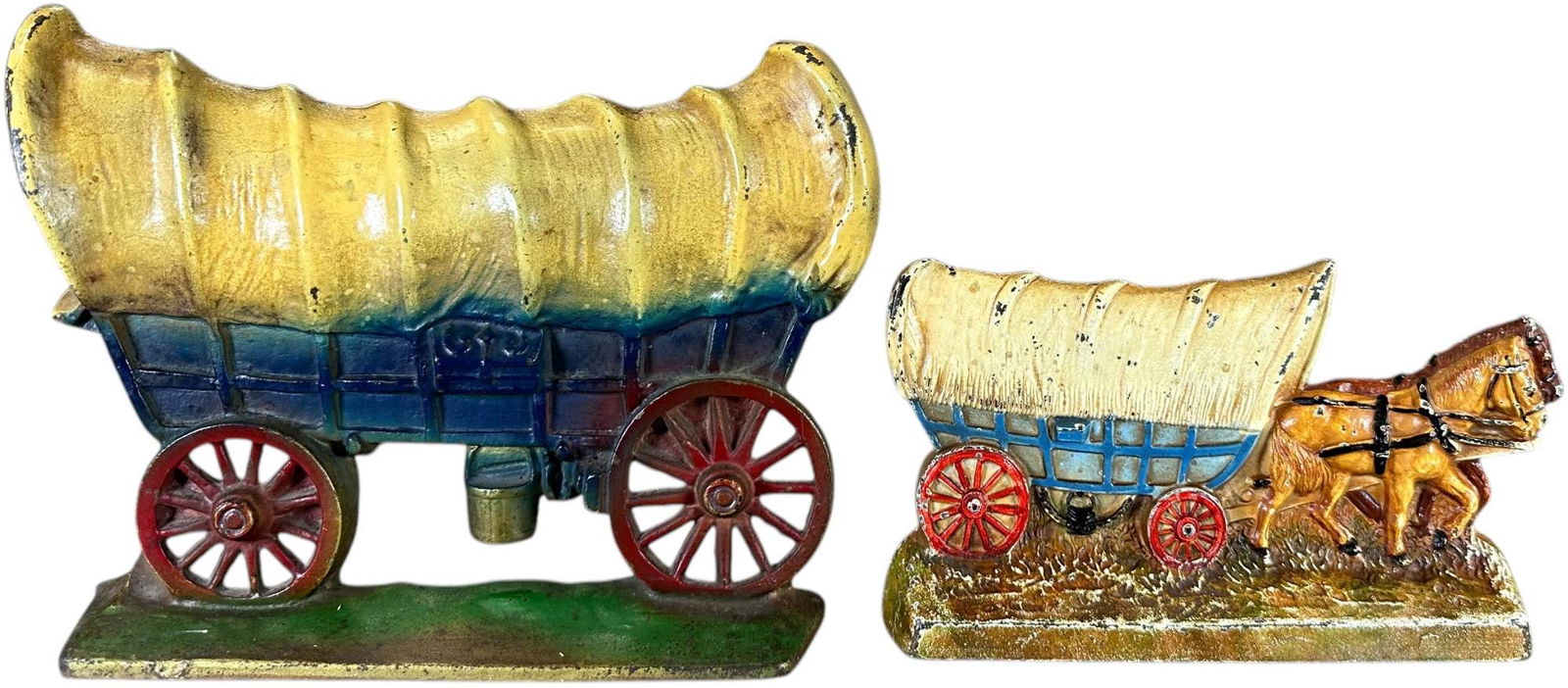 TWO CONESTOGA WAGON DOORSTOPS: 583. TWO CONESTOGA WAGON DOORSTOPS | Wagon with horses - marked Hubley "No. 375" retains original Hubley sticker. Large wagon - Creations Co. "No. 100". | 8.5" h. | (Excellent to Pristine Condition) |