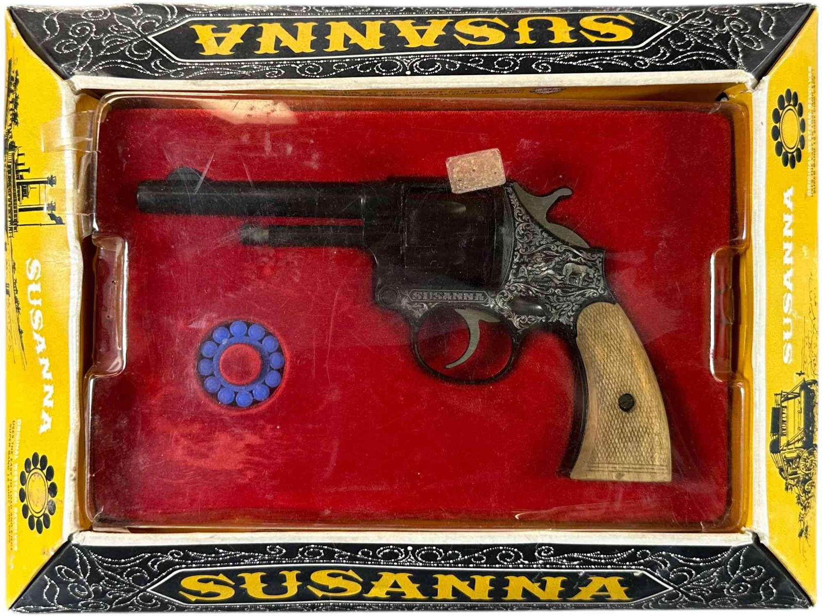 BOXED SUSANNA 12 SHOT 45 REVOLVER CAP GUN: 391. BOXED SUSANNA 12 SHOT 45 REVOLVER CAP GUN | #715 , made in Italy by Edison Giocattoli, with original box and caps. | 7.5 " l. | Plastic cracked in areas along edge, box has some light warping, ot
