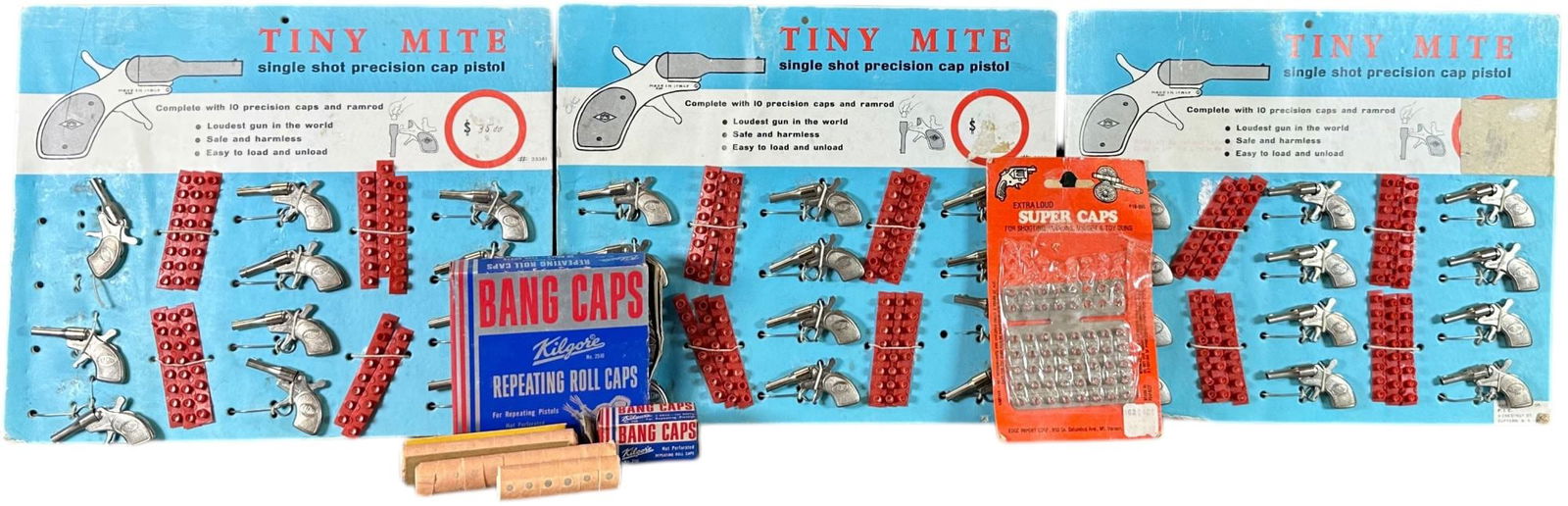 THREE DEALER DISPLAYS TINY MITE CAP PISTOLS: 396. THREE DEALER DISPLAYS TINY MITE CAP PISTOLS | Made in Italy and sold via PIC/NY, 12 guns per card. | 2" l. each gun | One gun and one strip of caps missing, some wear to cardboard edges, (Excelle
