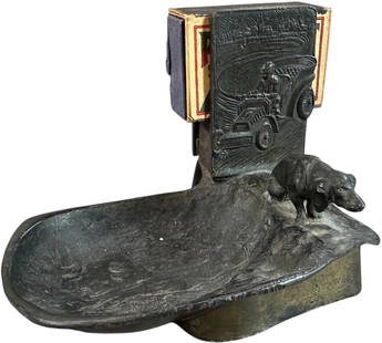 AUTOMOTIVE & DOG ASHTRAY W/ MATCH HOLDER: 193. AUTOMOTIVE & DOG ASHTRAY W/ MATCH HOLDER | Made of spelter. From the David Bausch Automobilia collection. | 5" l. | (Excellent Condition) | $200 - $400