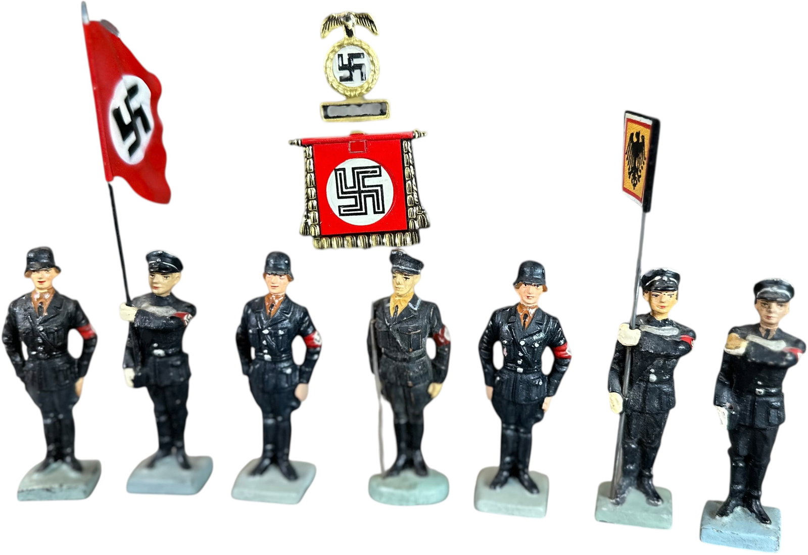 LINEOL SS STANDARD BEARERS: 221. LINEOL SS STANDARD BEARERS | Seven figure lot to include four SS standard bearers with tin flags and three SS soldiers at attention. From the Italian collection of Steno Tonelli. CULTURAL DISCLAI