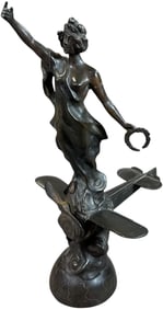 WOMAN HOLDING WREATH ATOP AN AIRPLANE STATUE