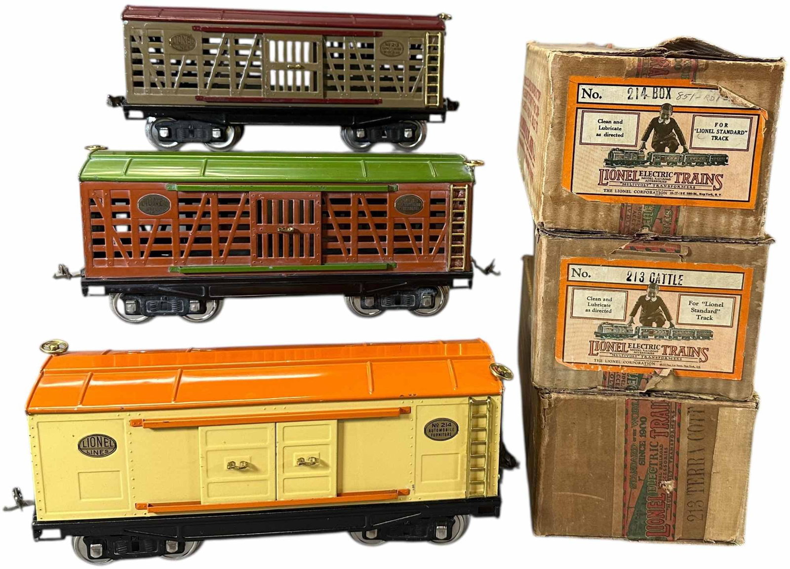 BOXED PREWAR LIONEL 214 & 213 CARS: 486. BOXED PREWAR LIONEL 214 & 213 CARS | Standard gauge. | 12" l. | Minor touch-up to frame on brown cattle car, minor damage to paint on ends of orange cattle car, overall (Excellent to Pristine Con