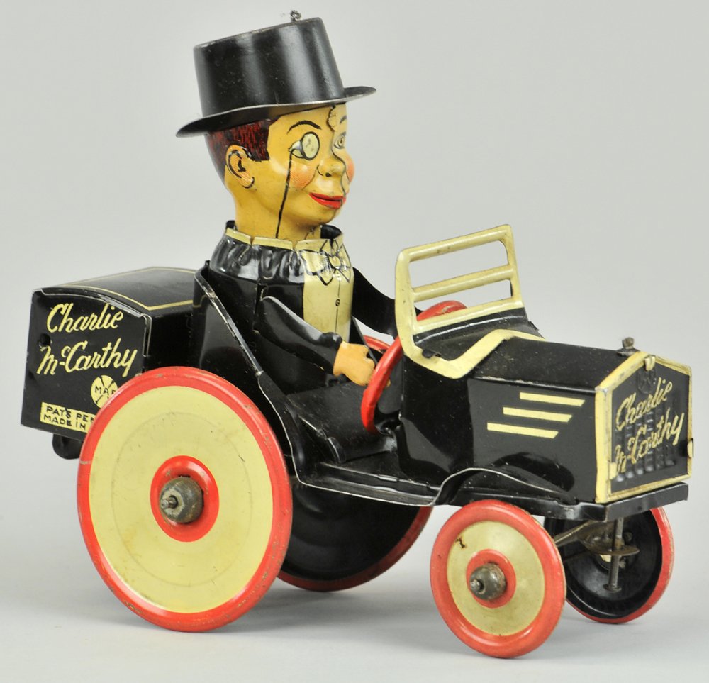 CHARLIE MCCARTHY BENZINE MOBILE: Louis Marx, red and white wheel version, clockwork creates active spinning of auto and head, lithographed tin. 7" l.