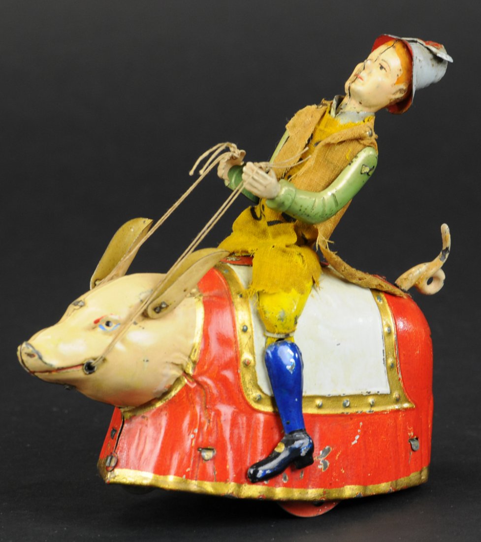 LEHMANN PADDY AND THE PIG: Germany, hand painted tin, an amusing and whimsical depiction of an Irishman riding a pig with blanket saddle, figure wears cloth outfit, clockwork driven, a classic Lehmann toy. 5 5/8" l.