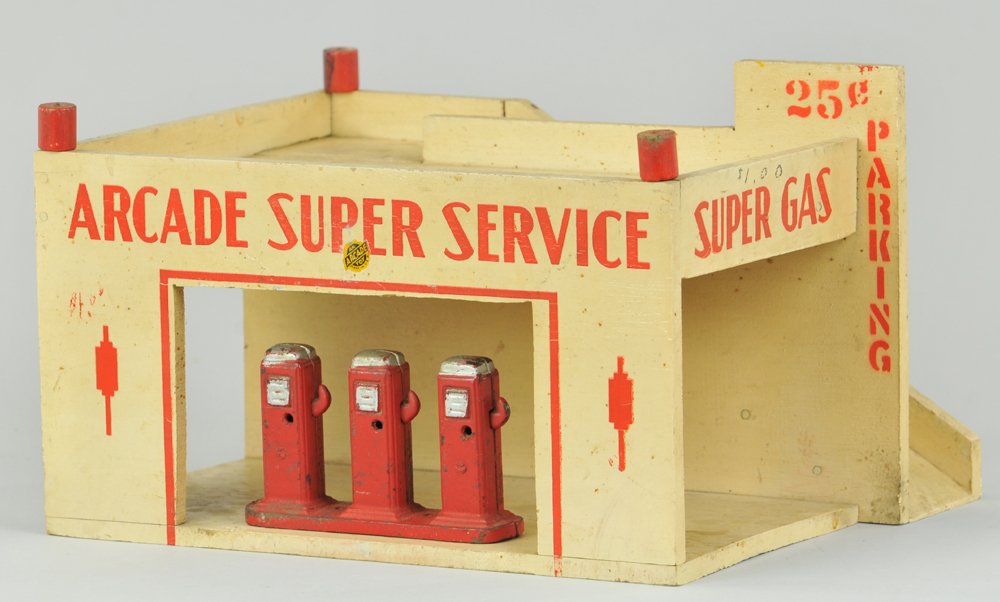 ARCADE "SUPER SERVICE" STATION: c. 1941, scarce wood gas station, painted in white overall, red trim and lettering, comes with three cast iron fuel pump island, rear ramp used for toy autos, side reads "Parking 25 cents," all origin