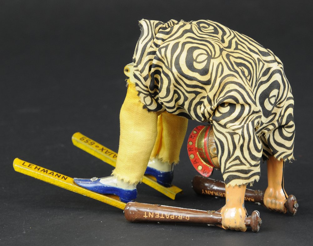 LEHMANN AJAX: Germany, incredible clockwork action, allows figure to do somersaults, cloth outfit, metal body, holds bats in hand, long post on feet. 9'' h.