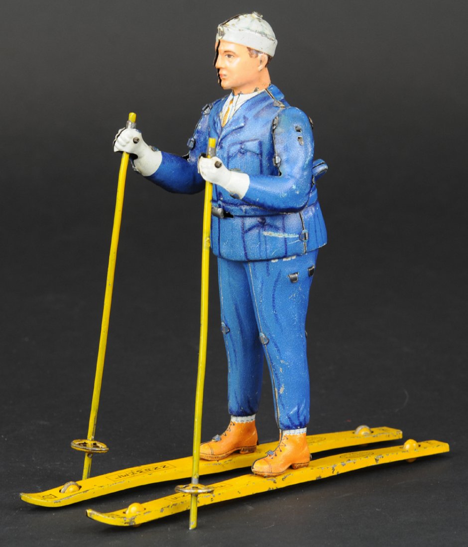 LEHMANN SKI ROLF: Germany, rare example, lithographed tin figure depiction in blue suit with white cap, stands on yellow skis w/poles in hands, clockwork driven, great action. 7" l.