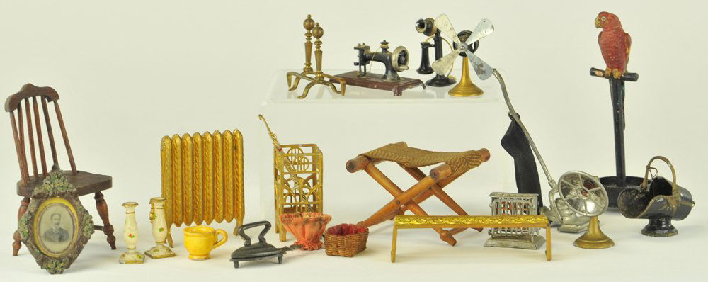 SEVERAL MINIATURE DOLLHOUSE ACCESSORIES: Twenty-one pieces, mostly 1920's, includes heater, fan, sewing machine, telephone, luggage rack holder, radiator, umbrella stand, toaster, parrot on stand, iron & trivet, vacuum, etc. 5 1/4" h.
