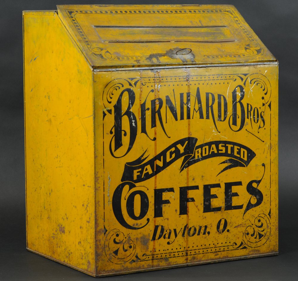 BERNHARD BROS. COFFEES STORE BIN: Early tin store bin marked, Bernhard Bros. Coffees, Dayton, O., lithographed tin, mustard & black coloring, slant front opening lid, product slide at lid, no product board present. 19 1/2" x 16" x 12 