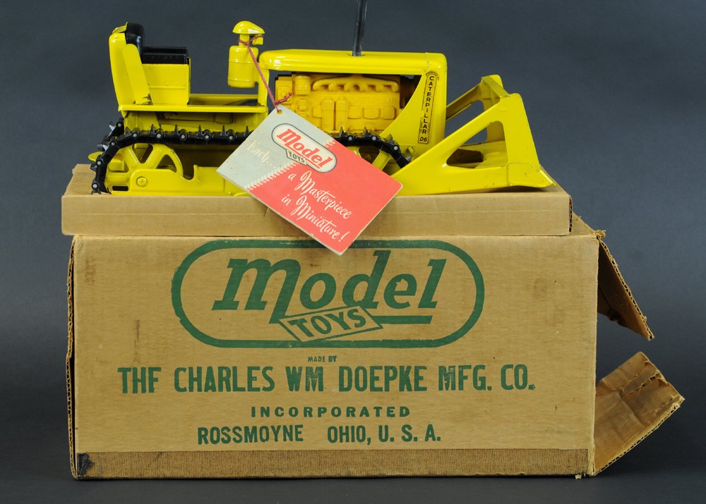 DOEPKE CATERPILLAR BULLDOZER WITH BOX: Painted in yellow overall, pressed steel with plastic components, includes original stack and treads booklets included. 15" l.