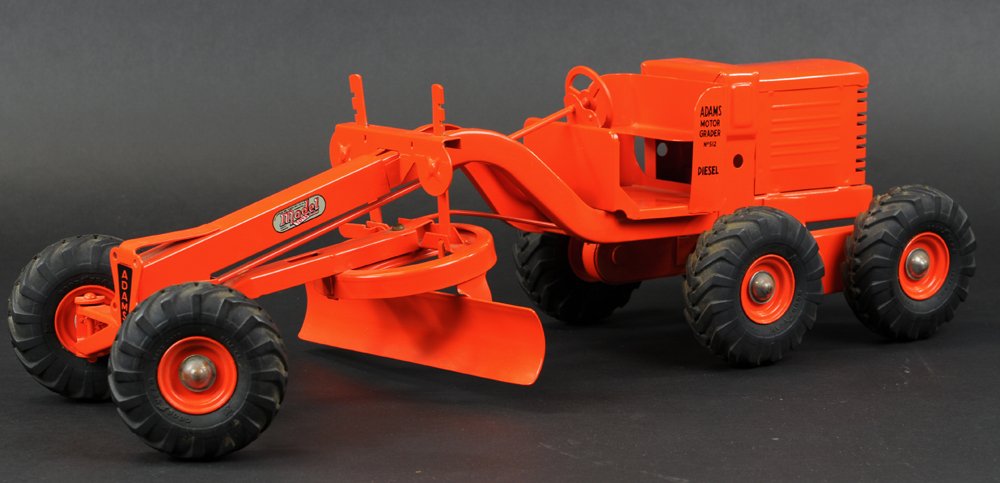 DOEPKE ADAMS MOTOR GRADER TOY: Pressed steel, painted in orange overall, black rubber tires marked "Good Year," sticker reads "Charles Doepke Mfg. Co. Model Toys, Adams" decals on both sides. 24" l.