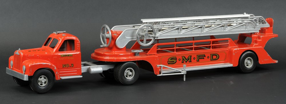SMITH MILLER S.M.F.D. LADDER TRUCK: Die-cast, enclosed Mack Cab, painted in red overall, open service body features extension ladders, side stabilizers and full levers for rotations, rubber tires. 34" l.