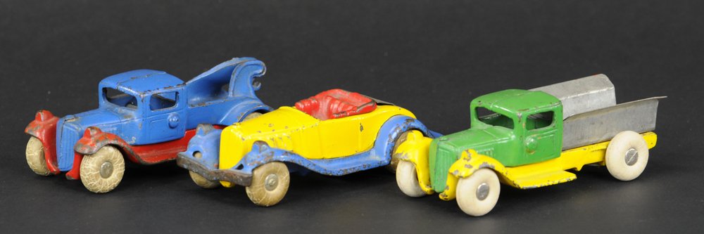 THREE KILGORE TAKE-APART VEHICLES: Cast iron, classic wire held colorful trucks and auto, includes Wrecker, Dump truck, and Roadster with opening rumble seat, all with rubber tires, dump bed & rumble seat made of tin. 4 3/4" l.