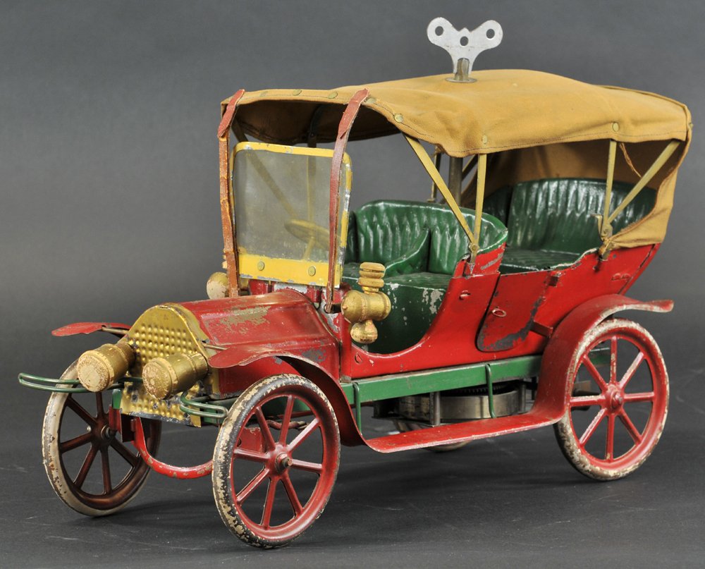 CONVERSE TOURING AUTO: c. 1908, an early pressed steel tourer done in red body, green seating, canvas tarp rolls down, clockwork driven, key is turned through rivet in roof. 15" l.