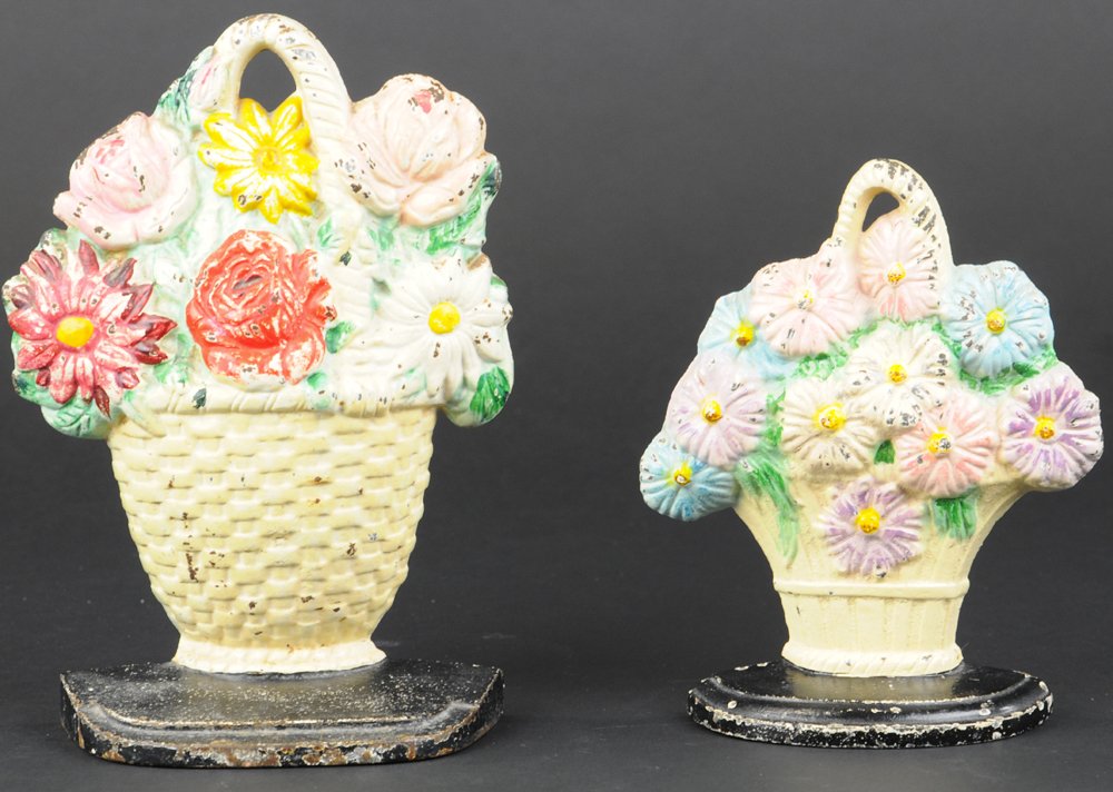 LOT OF TWO DAISIES DOORSTOP: Includes Hubley "344," lovely doorstop depicting pastel colored daisies in cream colored basket & Hubley Basket "357" of colorful detailed flowers with original Hubley sticker on back. 6 3/4" h.