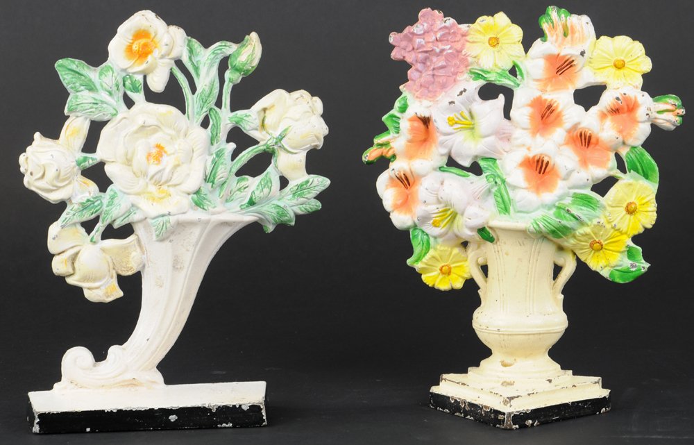 LOT OF TWO HUBLEY FLOWER DOORSTOPS: Includes Hubley "489," Gladiolas, fine casting details, brightly colored pastel flowers, tall urn vase in cream, along with Hubley "441," Rose slanted vase on black base. 10" & 10 1/2 h.