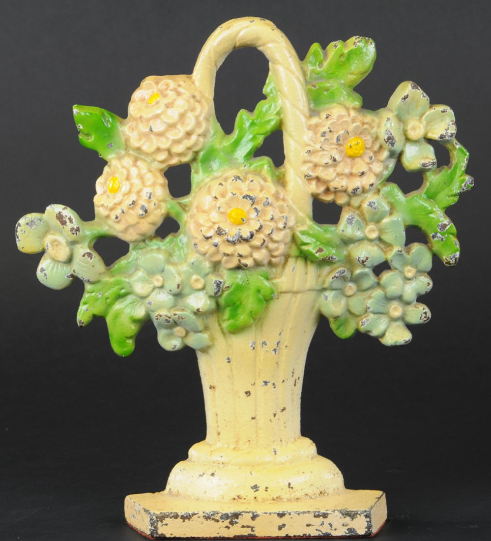 BASKET OF ZINNIAS DOORSTOP: Rare cast iron doorstop depicting beautiful flowers overflowing from ribbed basket with handle, great detail. 11" h.