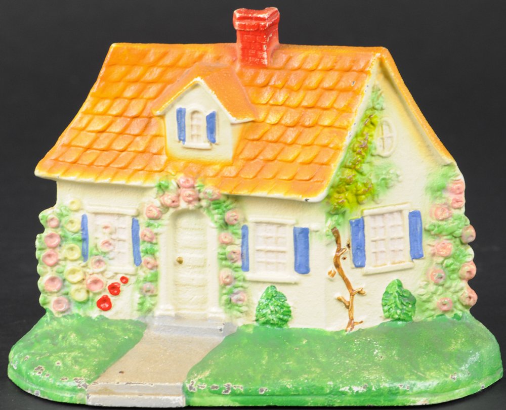 CAPE COD COTTAGE DOORSTOP: Hubley "211," white cottage depicted with flowers growing along walls & surrounding doorway, fine casting details overall. 5 3/4" h.