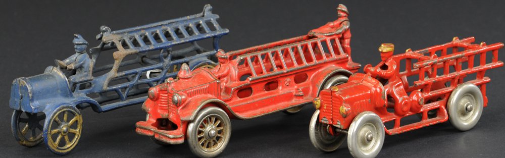 LOT OF THREE FIRE LADDER TRUCKS: Cast iron grouping, all with seated cast in driver, two painted in red, one in blue, spoke and disc wheel examples. 6 3/4" to 7 1/2" l.