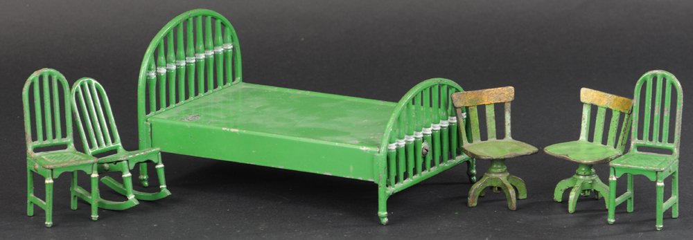 ARCADE DOLL HOUSE CAST FURNITURE: Cast iron, all painted in green overall, lot includes: bed, two office chairs, rocking chair, and two kitchen chairs. 4" h. to 8" l.