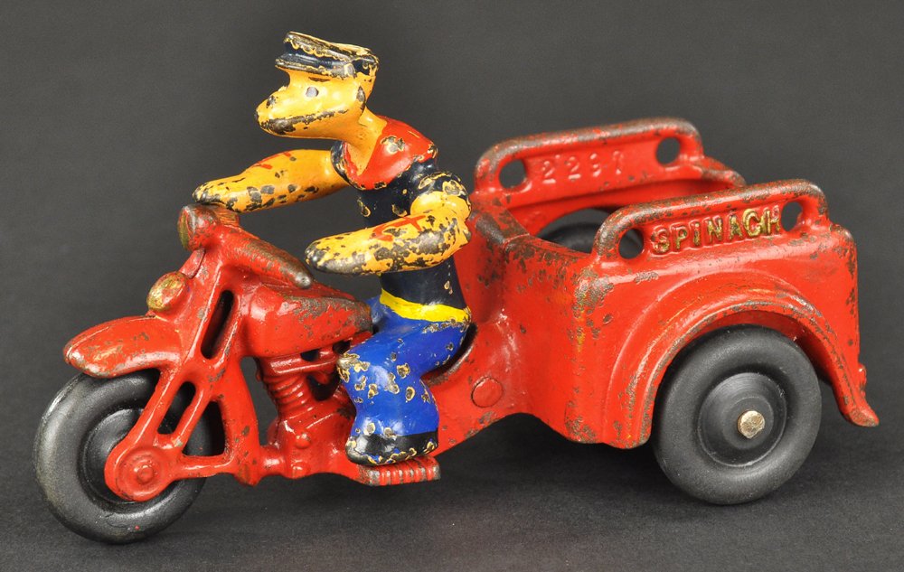 POPEYE SPINACH CART: Hubley, cast iron, painted in red w/removable Popeye figure, "Spinach" embossed on cart sides, black rubber wheels. 5 1/4" l.