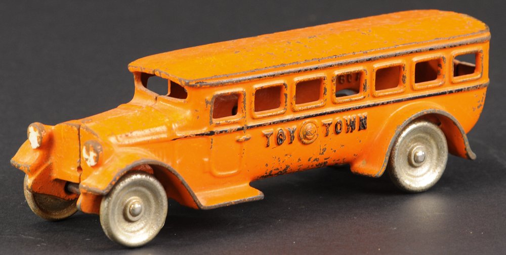 KILGORE "TOY TOWN" BUS: Scarce example, c. 1930, cast iron, painted in orange body, black striping, cast lights, nickel disc wheels, embossed lettering on sides. 7 3/4" l.