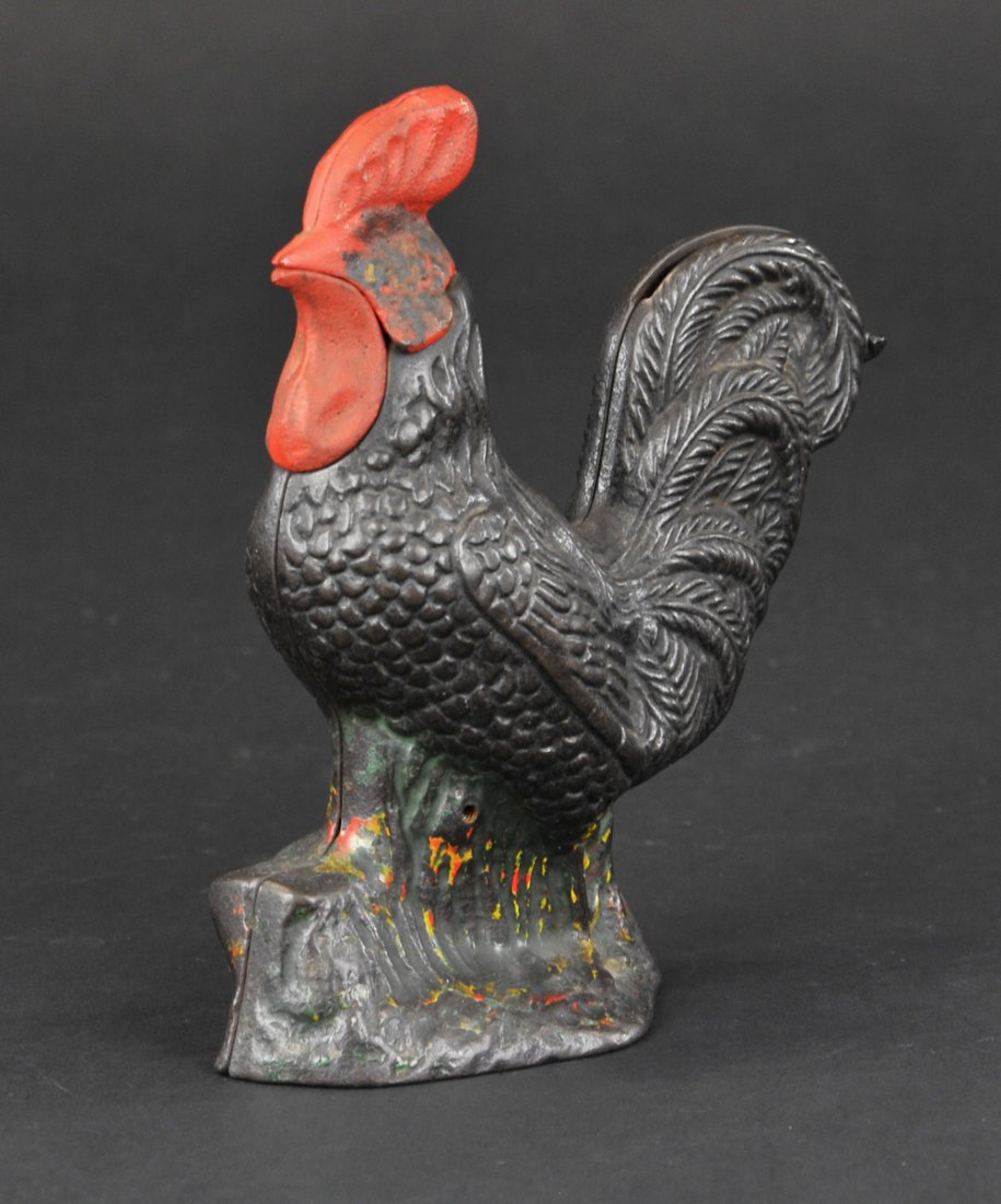 ROOSTER MECHANICAL BANK: Kyser & Rex Co., circa 1880's. Set a coin in the slot in the rooster’s tail and slowly move the lever downward; the rooster moves his head several times in a crowing motion as the coin falls into th