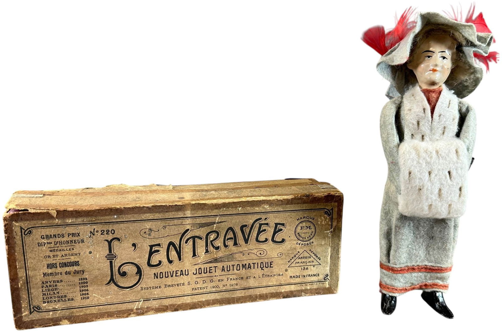 BOXED FERNAND MARTIN PARISIAN WOMAN: 285. BOXED FERNAND MARTIN PARISIAN WOMAN | France, circa 1910, wind-up motor, "L'Entravee" (the Hobbled One), an absolutely beautiful toy and a classic depiction of what Fernand saw daily on the turn