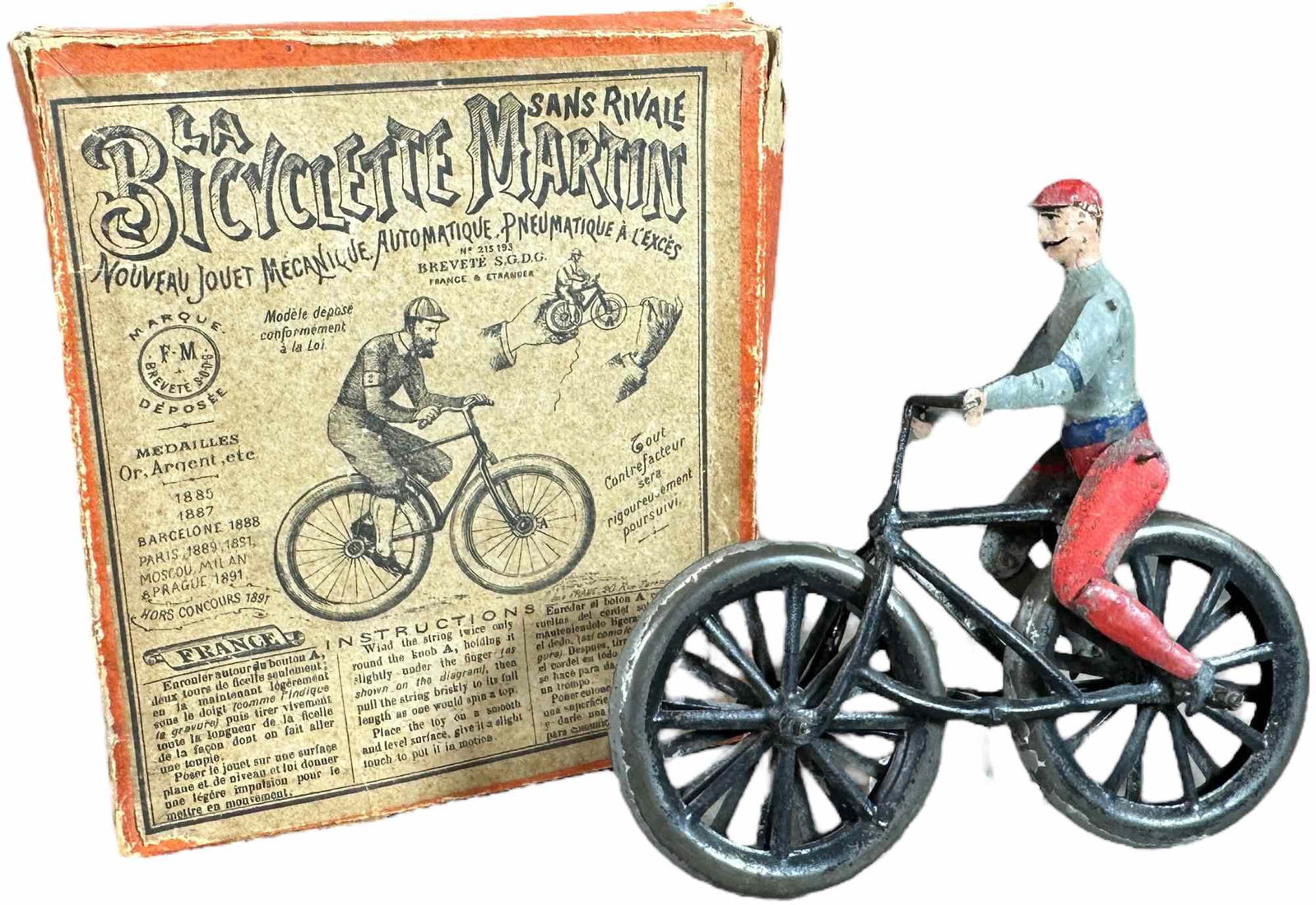 BOXED FERNAND MARTIN CHAMPION CYCLISTE: 353. BOXED FERNAND MARTIN CHAMPION CYCLISTE | France, circa 1892, "La Bicyclette", this is rare toy with extremely rare original box, flywheel mechanism causes the rider to cycle quickly and balance w
