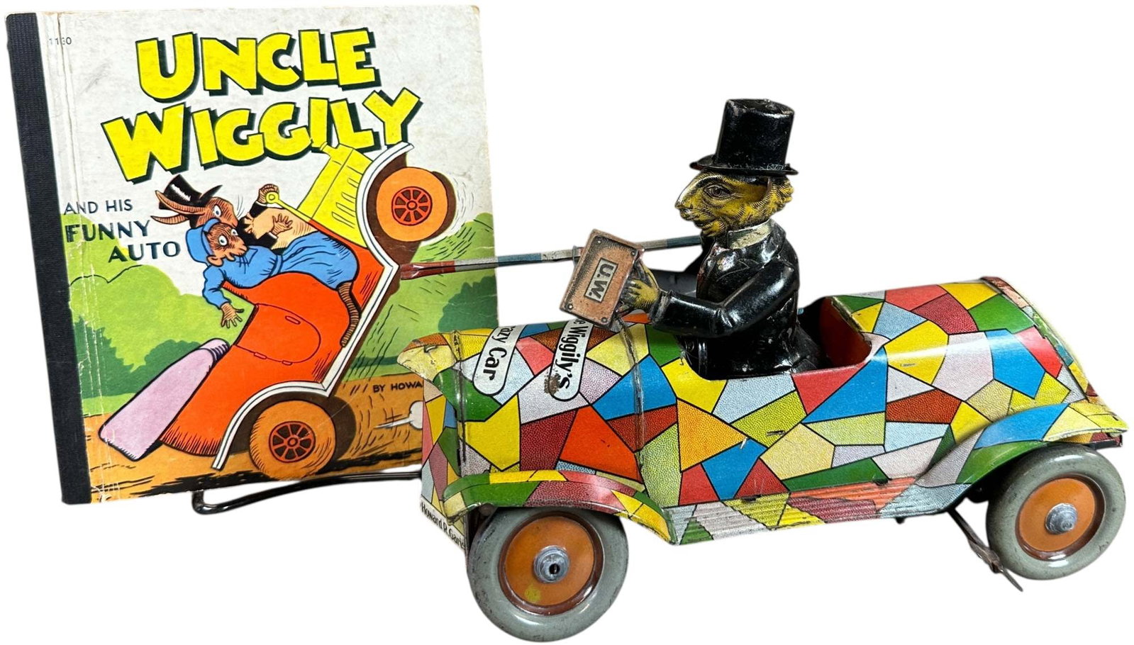 DISTLER UNCLE WIGGLY CRAZY CAR: 370. DISTLER UNCLE WIGGLY CRAZY CAR | Germany, wind-up motor drives cart forward as the rabbit turns body side to side, accompanied with a children's book. | 9.5" l. | All original in (Excellent Condi