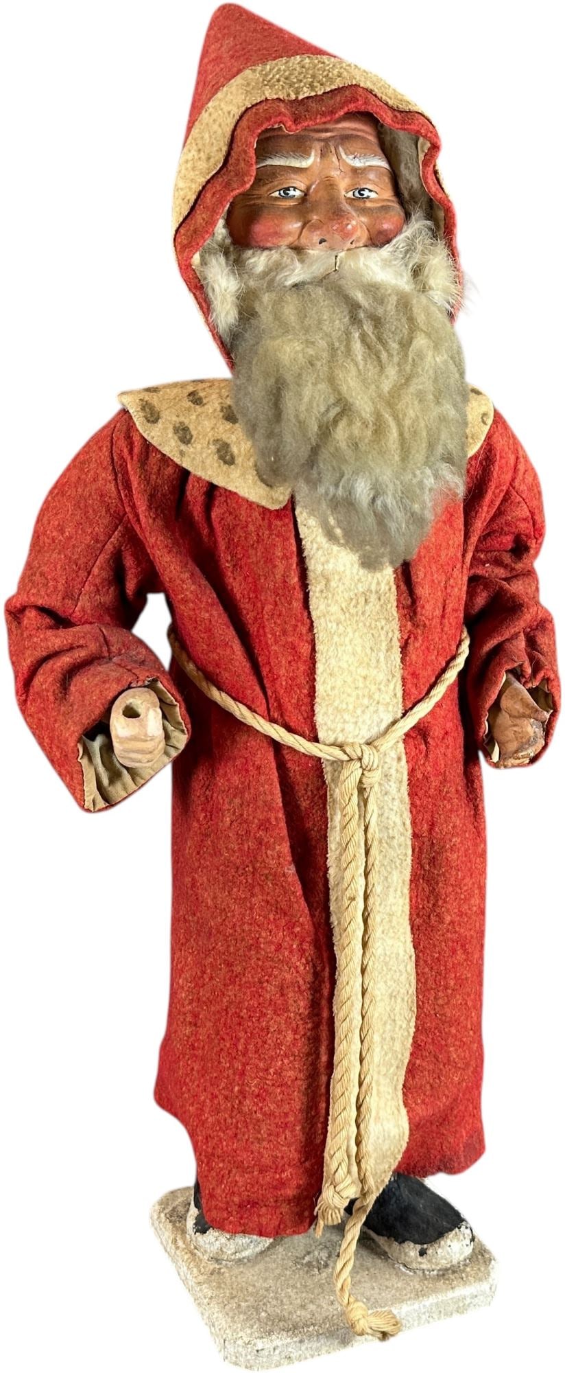 TALL CLOCKWORK SANTA W/ POINTED HAT: 25. TALL CLOCKWORK SANTA W/ POINTED HAT | This is large and impressive, clockwork mechanism wound at side to allow head to nod. | 24" h. | Incredible face & well preserved robe, the slightest touch up