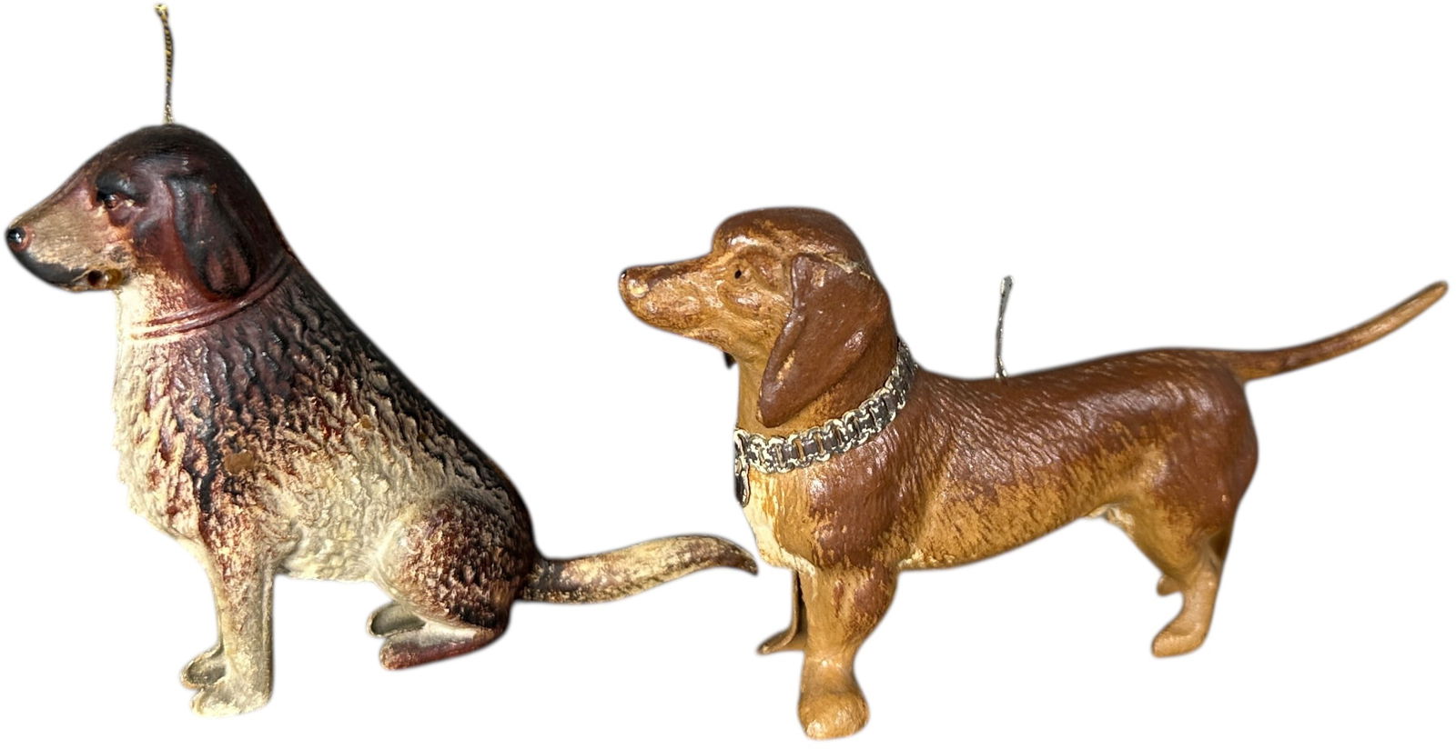 TWO DRESDEN DOG ORNAMENTS: 144. TWO DRESDEN DOG ORNAMENTS | Dachshund still has original collar. Provenance: Jerry & Darla Arnold Collection. | 4" l. | Sitting dog has replacement tail, (Excellent Condition) | $600 - $1,000