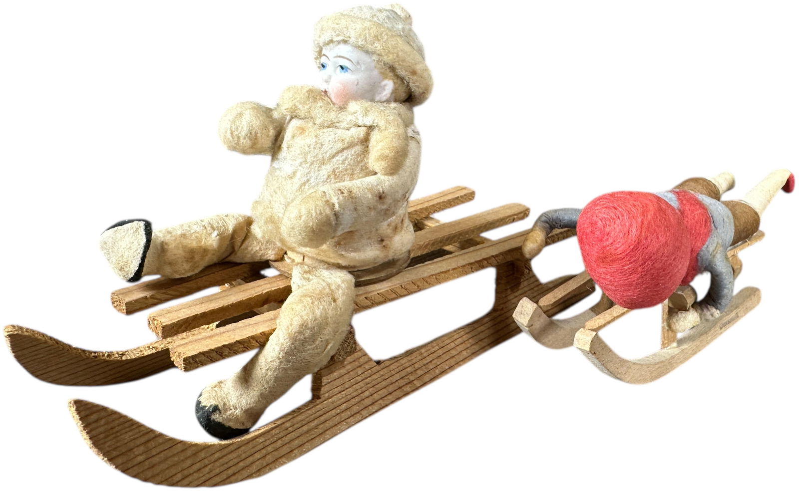 TWO HEUBACH SLEDDING CHILDREN: 263. TWO HEUBACH SLEDDING CHILDREN | Sitting figure is a candy container. Provenance: Linda Morrow Collection | 6" l. | (Excellent Condition) | $600 - $1,000