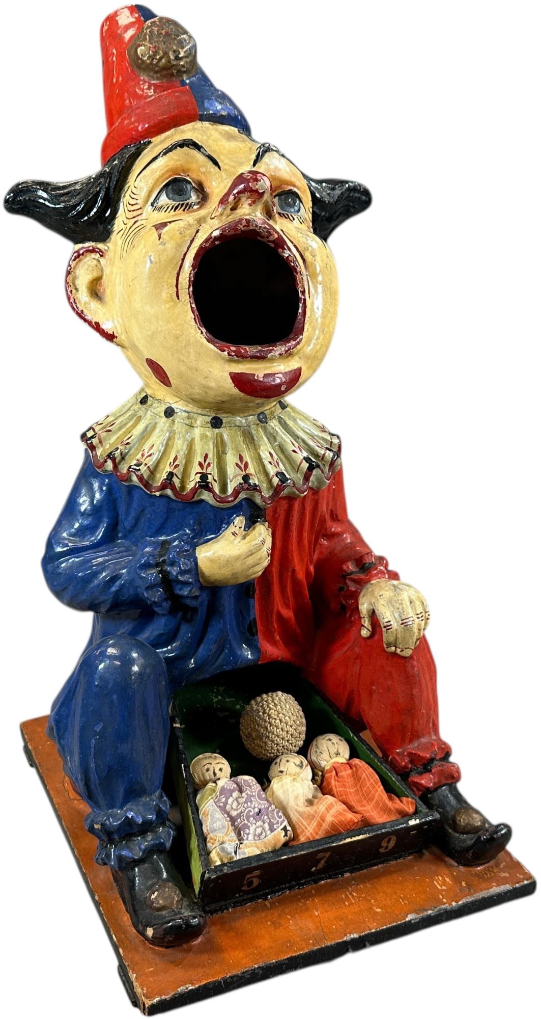 COLORFUL CLOWN BALL TOSS FIGURE: 361. COLORFUL CLOWN BALL TOSS FIGURE | Attributed to Germany, wonderfully detailed composition figure of a seated clown with open mouth to receive ball toss, great colors, includes period cloth dolls