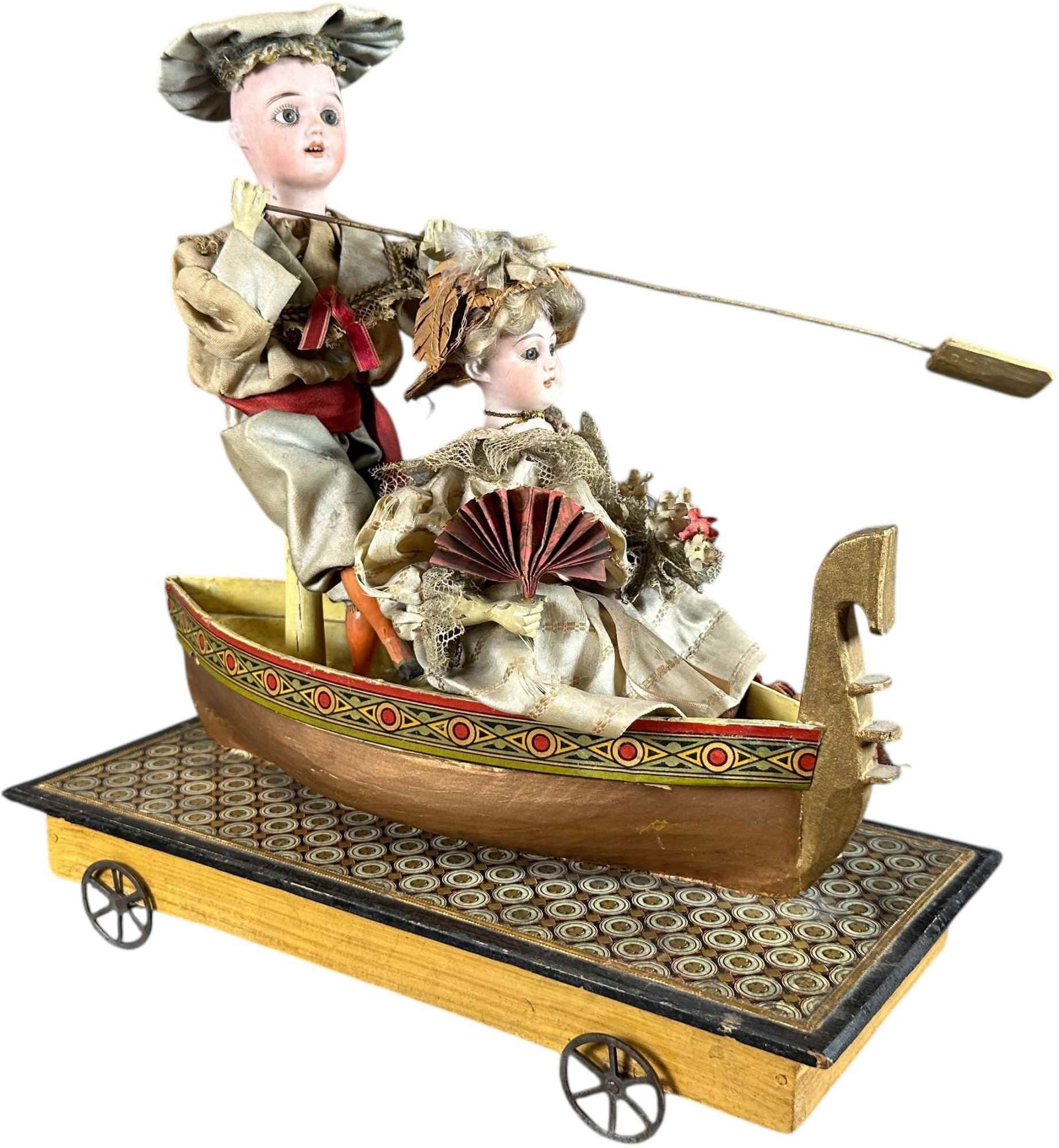 GERMAN CHILDREN IN GONDOLA MECHANICAL PULL TOY: 423. GERMAN CHILDREN IN GONDOLA MECHANICAL PULL TOY | Charming example of two children in a gondola, doll's head incised with markings of German doll maker Schoenau & Hoffmeister, when pulled along,