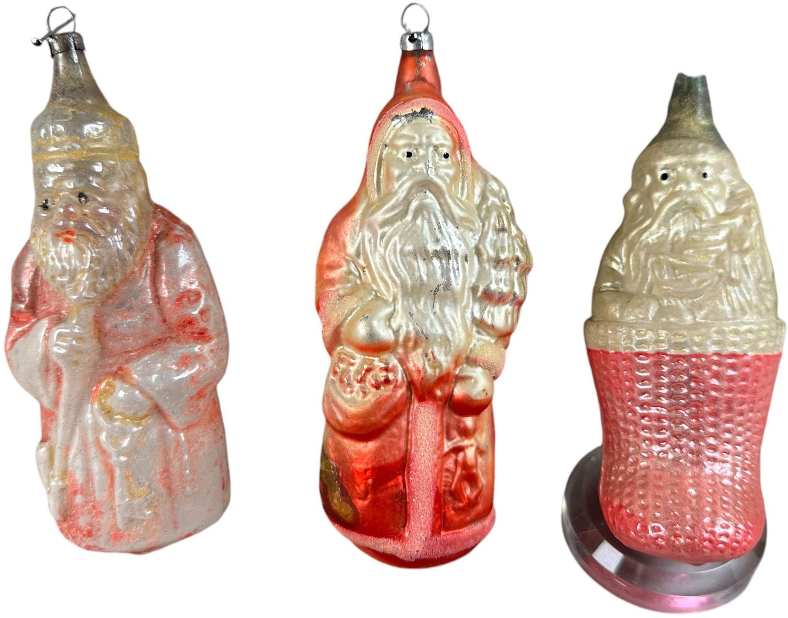 THREE GLASS SANTA ORNAMENTS: 1026. THREE GLASS SANTA ORNAMENTS | Santa in stocking is missing the cap. | 4"-4.5" h. | Some paint loss, (Excellent Condition) | $200 - $400