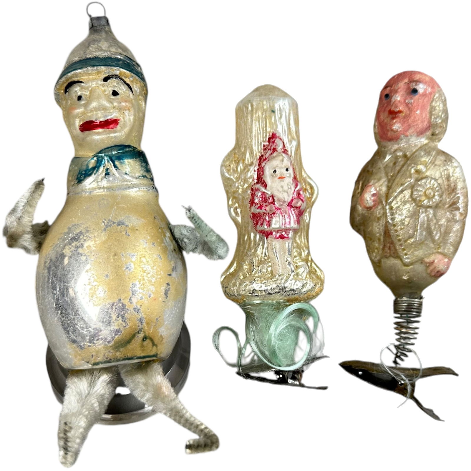 THREE GLASS FIGURE ORNAMENTS: 1072. THREE GLASS FIGURE ORNAMENTS | Man in cap with chenille legs, man on clip, and Santa embossed on tree. | 4"-5" h. | (Excellent Condition) | $300 - $500