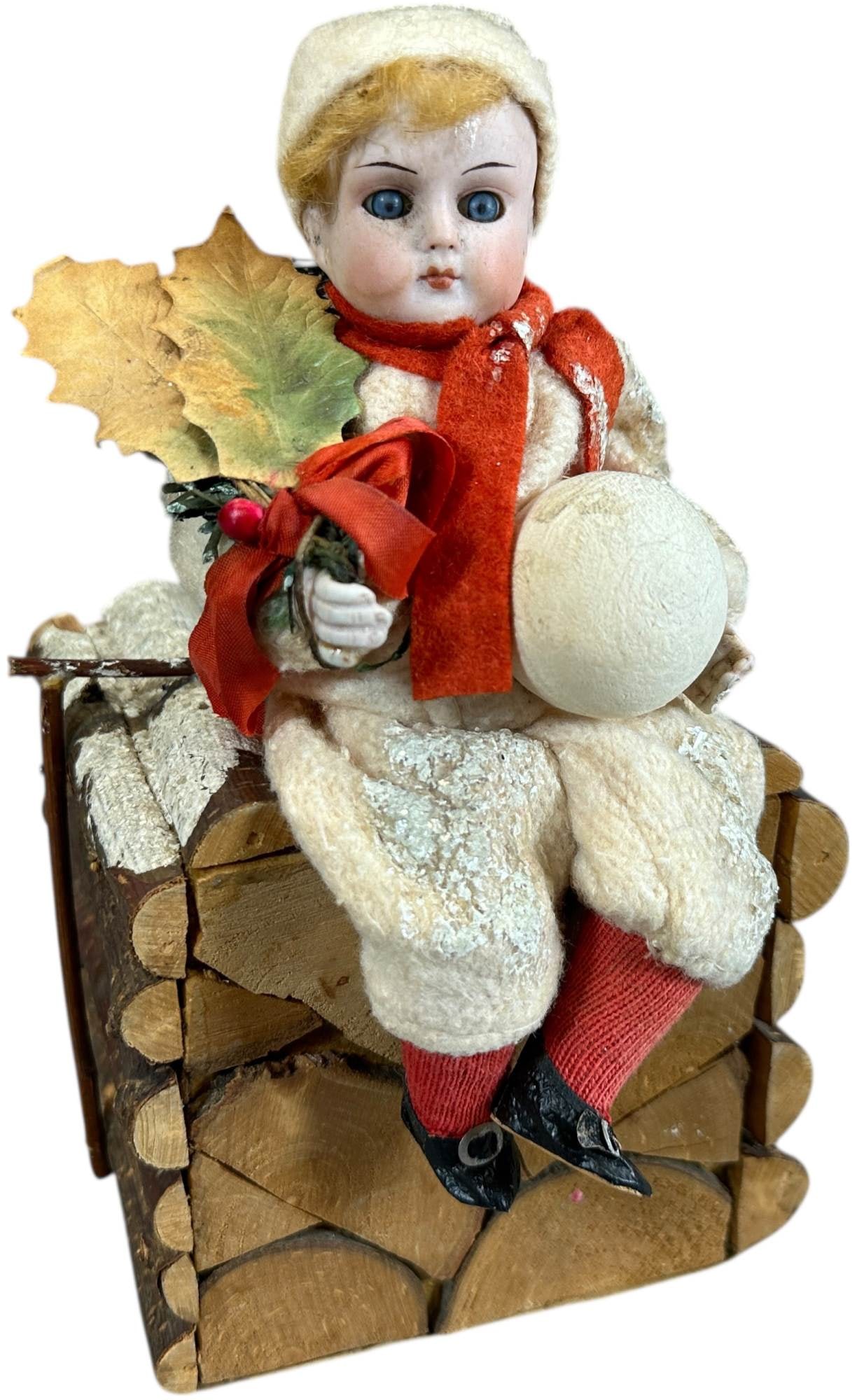 GIRL ON LOG PILE CANDY CONTAINER: 1170. GIRL ON LOG PILE CANDY CONTAINER | Made in Germany, bisque head girl sitting on a large log covered candy box marked Germany on the bottom. Provenance: Bob & Maurine Young | 9.5" h. | Contempora