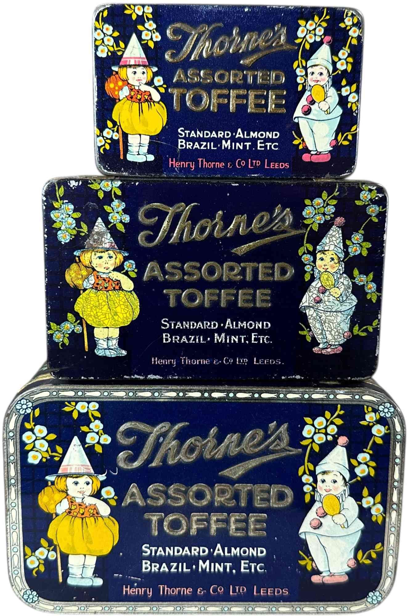 THREE THORNES ASSORTED TOFFEE TINS: 1259. THREE THORNES ASSORTED TOFFEE TINS | Girl holding pumpkin on stick on top off each tin. | 6.5" l. | (Excellent Condition) | $300 - $500