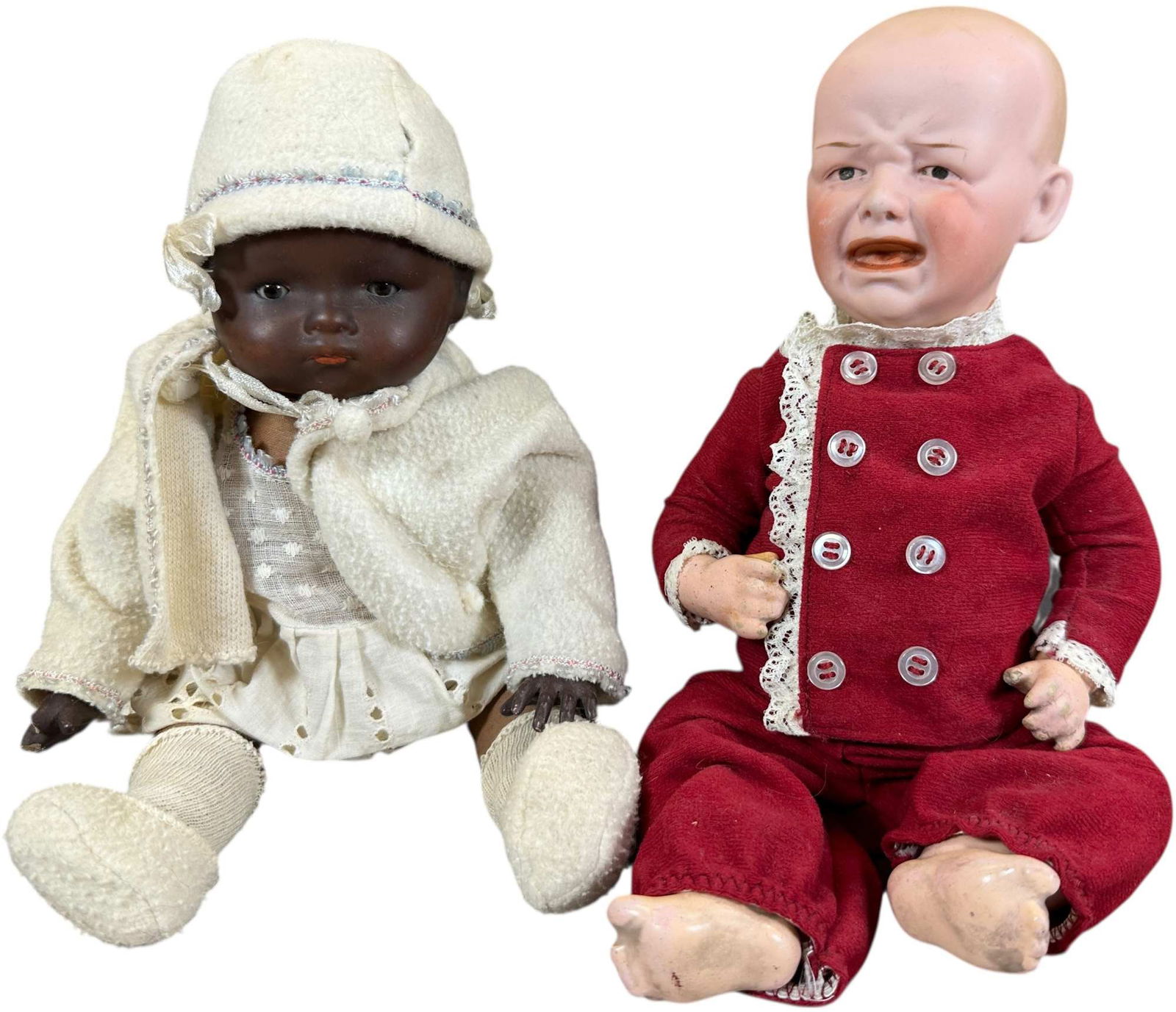 TWO GERMAN BISQUE BABY DOLLS: 1431. TWO GERMAN BISQUE BABY DOLLS | The brown bisque baby is incised "AM Germany 341", with brown glass sleep eyes, a flange near socket mounted to a brown cloth body with composition hands, larger d