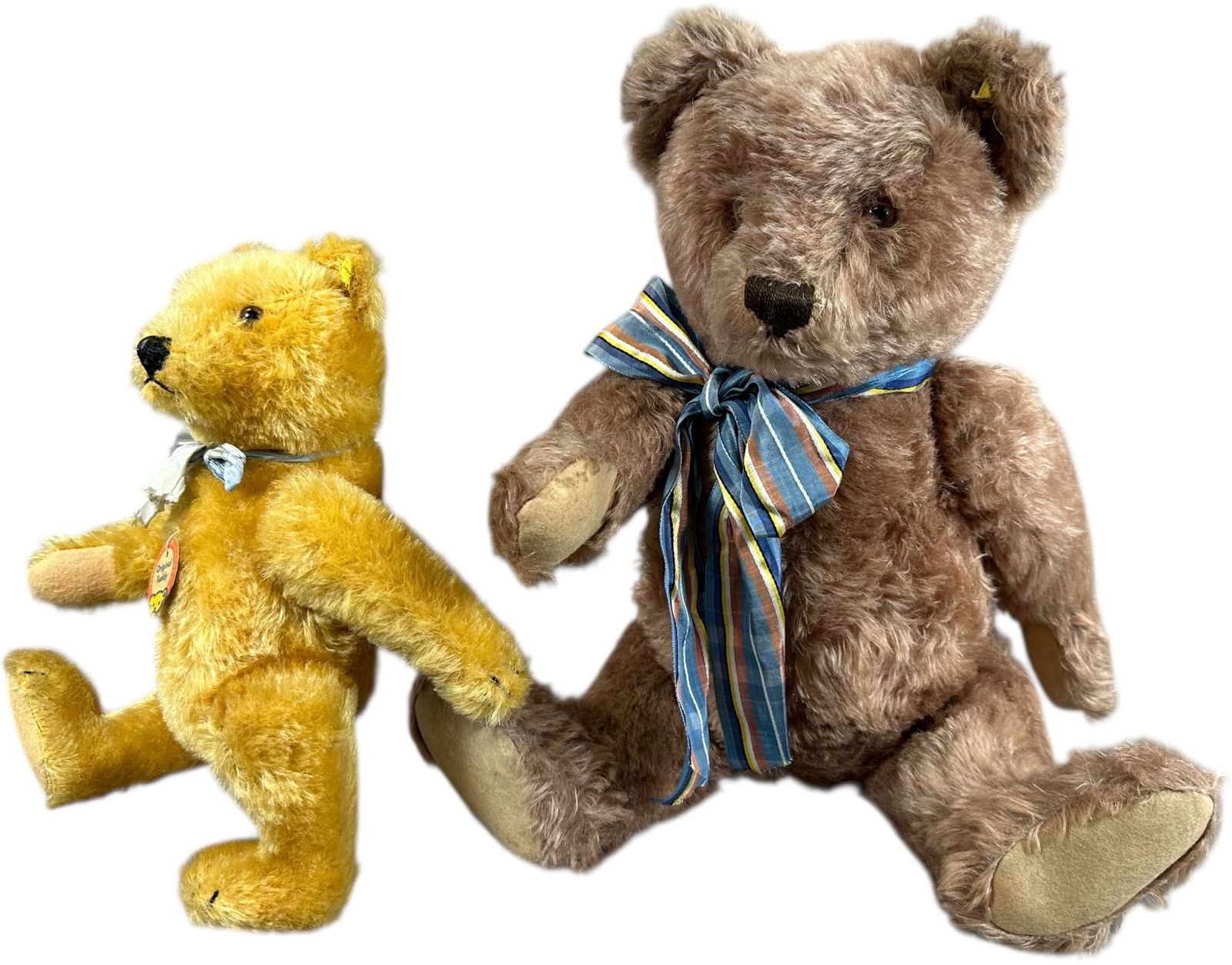 STEIFF TWO 1950S TEDDY BEARS: 1520. STEIFF TWO 1950S TEDDY BEARS | Both with raised script buttons, larger bear is a rare "Rose Tinted" color mohair, smaller gold bear has original chest tag and faded blue silk ribbon neck